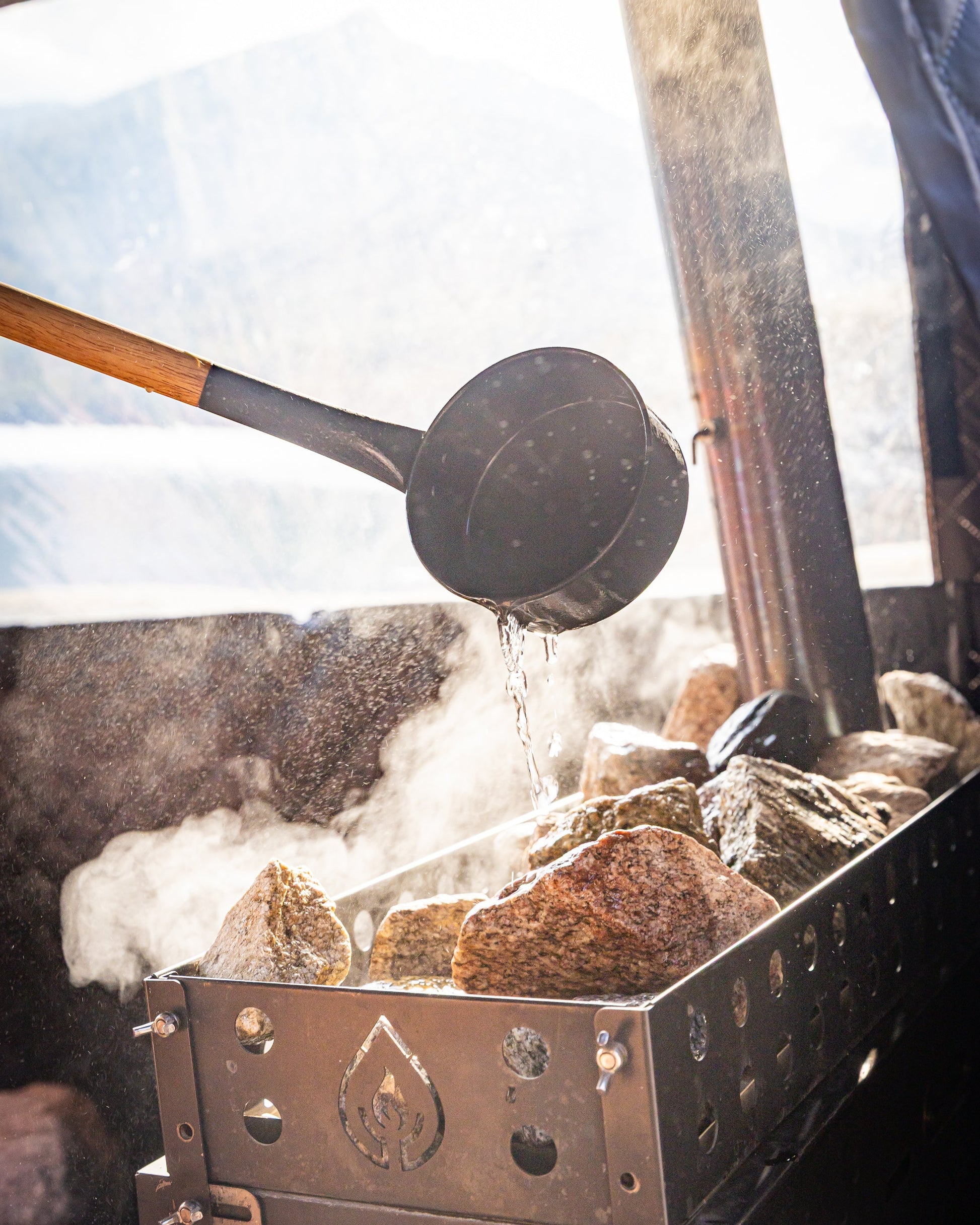 Steam rising from hot sauna rocks and thermaculture sauna ladle