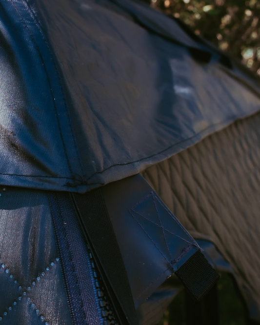 Close-up of a textured fabric surface with a blurred natural background
